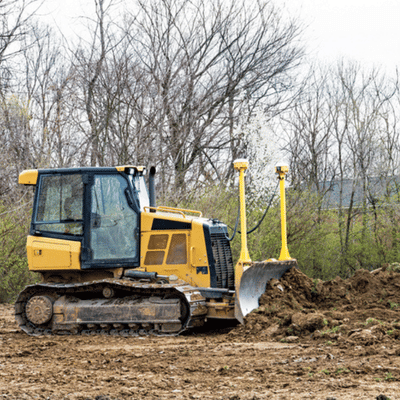 Bulldozer pushes dirt across open lot, as site preparation contractors clear and grade terrain