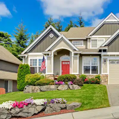 Modern suburban house with manicured lawn and flowerbeds, demonstrating tidy curb appeal and maintained landscaping