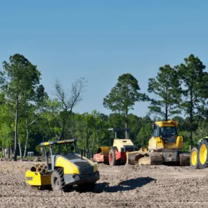 Bulldozers and rollers preparing land for building projects through efficient commercial land clearing techniques