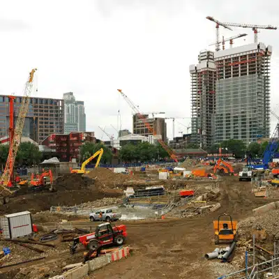 Large urban construction site with cranes and equipment, highlighting costly rework in construction from mistakes